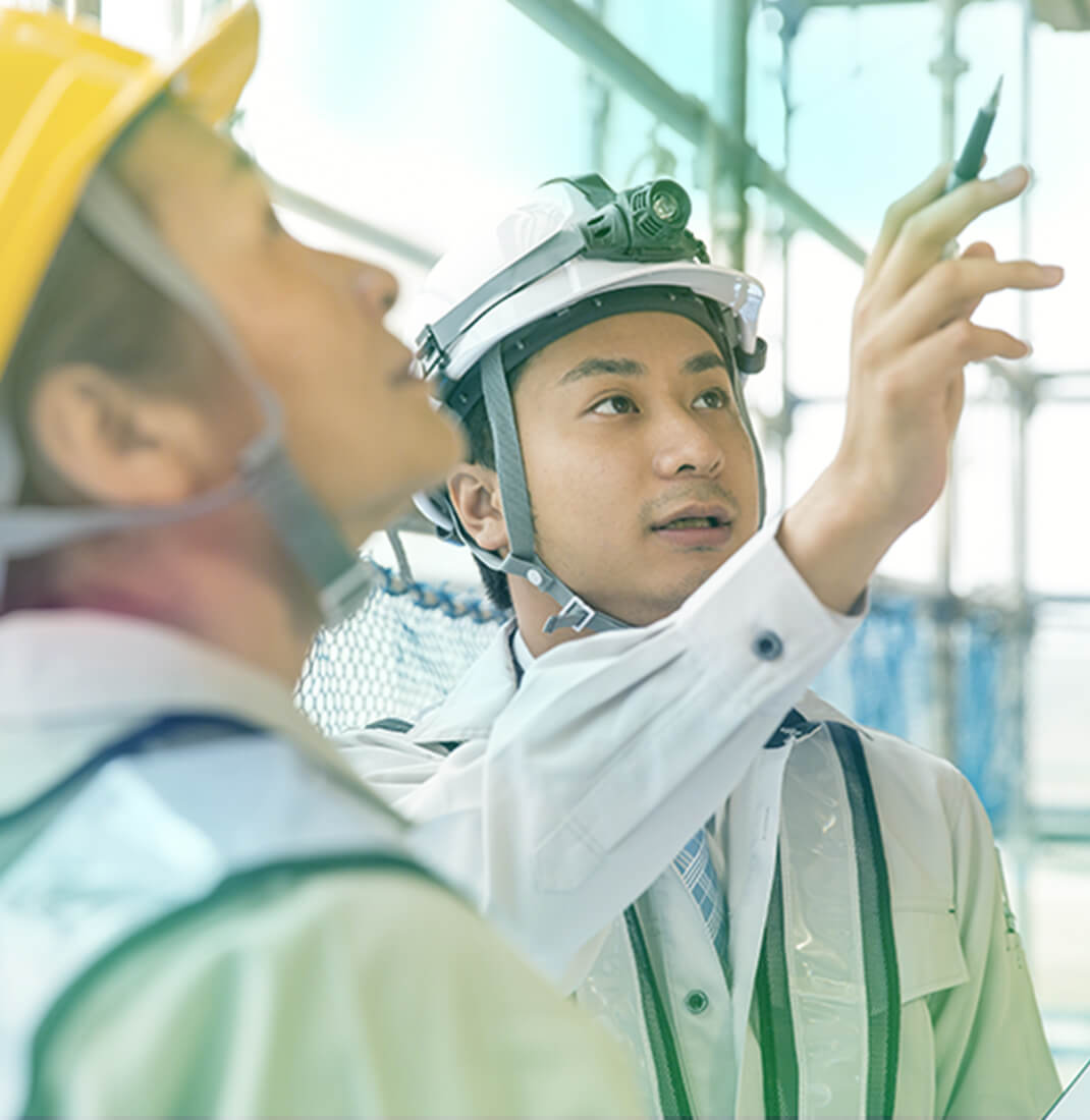 画像:施工現場で指示を確認し合うスタッフ